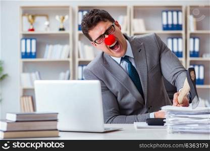 Clown businessman in the office with an axe