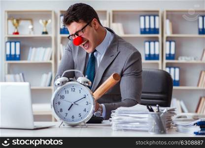 Clown businessman in the office with baseball bat and an alarm c. Clown businessman in the office with baseball bat and an alarm clock