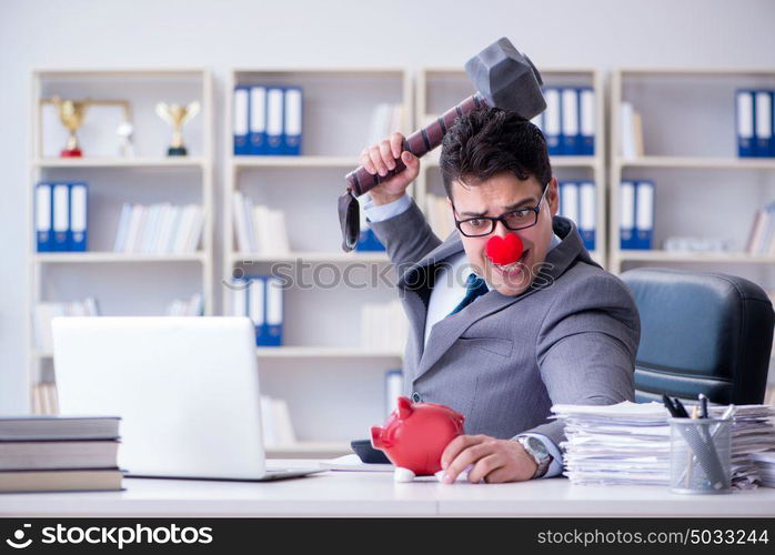 Clown businessman with a piggy bank and a hammer