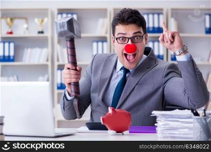 Clown businessman with a piggy bank and a hammer