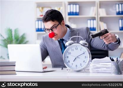 Clown businessman working in the office angry frustrated with a . Clown businessman working in the office angry frustrated with a gun