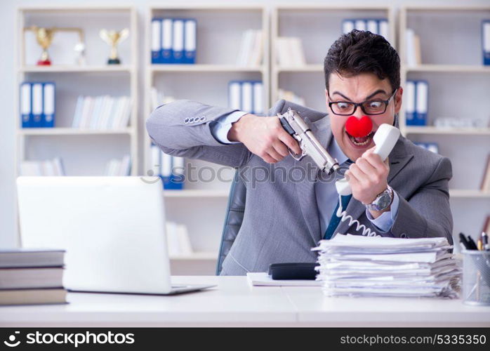 Clown businessman working in the office angry frustrated with a . Clown businessman working in the office angry frustrated with a gun