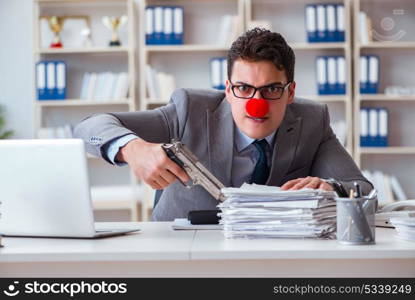 Clown businessman working in the office angry frustrated with a . Clown businessman working in the office angry frustrated with a gun