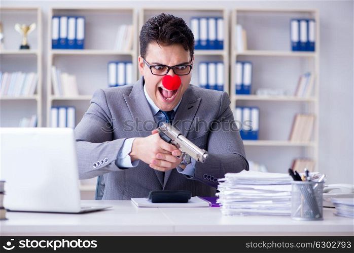 Clown businessman working in the office angry frustrated with a . Clown businessman working in the office angry frustrated with a gun