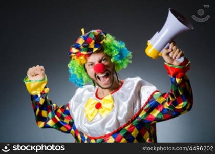 Clown with loudspealer against curtain