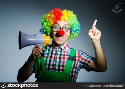 Clown with loudspealer against curtain