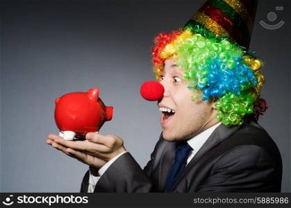 Clown with piggybank in funny concept