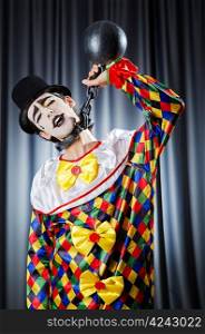 Clown with shackles in studio