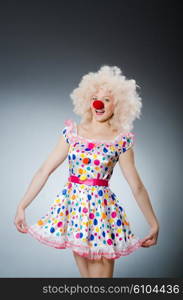 Clown with white wig against grey background