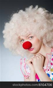 Clown with white wig against grey background