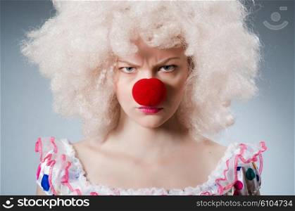 Clown with white wig against grey background