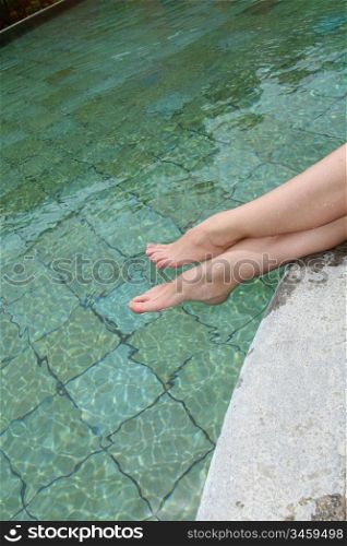 Clsoeup on woman&acute;s legs by swimming pool