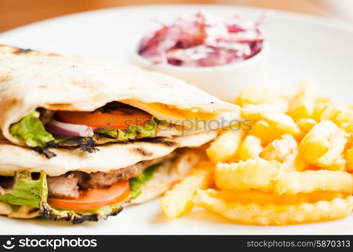 Club sandwich in pita with fried potato and salad