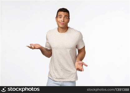 Clueless handsome young hispanic muscular man in casual t-shirt, shrugging, spread arms sideways, smirk and look indecisive, dont know how solve situation, standing puzzled and confused.. Clueless handsome young hispanic muscular man in casual t-shirt, shrugging, spread arms sideways, smirk and look indecisive, dont know how solve situation, standing puzzled and confused