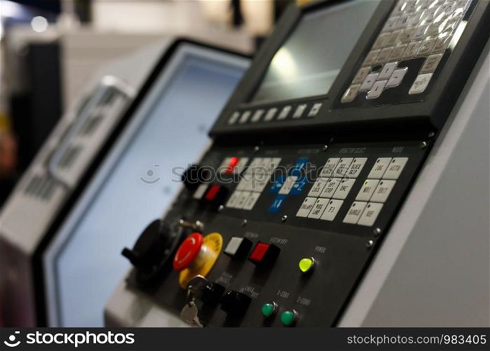 CNC metalworking machine with the control panel in the foreground. Selective focus.