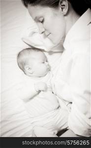 co-sleeping mother and three months baby after breastfeeding on the bed. co-sleeping mother and baby