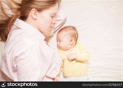 co-sleeping mother and three months baby after breastfeeding on the bed. co-sleeping mother and baby