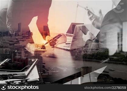 co working meeting,two businessman using VOIP headset with latop computer on desk in modern office as call center and customer service help desk concept with London city background,double exposure