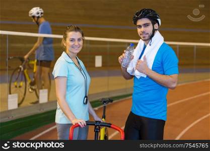 coach and cyclist showing thumb-up at a velodrom