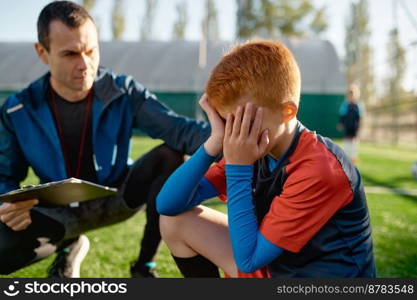 Coach comforting crying little soccer player after missed goal. Kids soccer football concept. Coach comforting crying little soccer player after missed goal