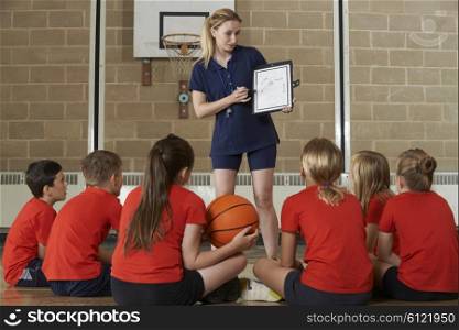 Coach Giving Team Talk To Elementary School Basketball Team