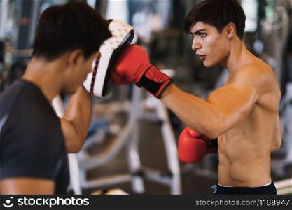 Coach thai are training men boxer with boxing glove at the gym, fitness, boxing camp.