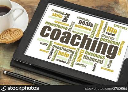 coaching concept - a related word cloud on a digital tablet with cup of coffee