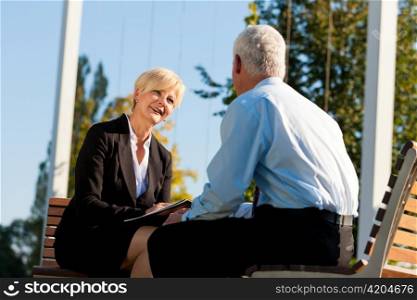 Coaching outdoors - a man and a woman have a coaching discussion