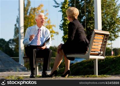 Coaching outdoors - a man and a woman have a coaching discussion
