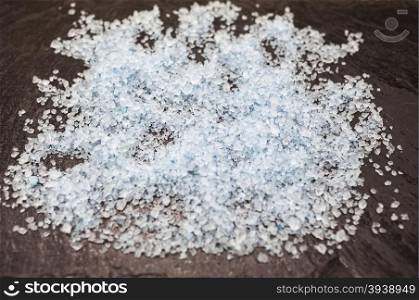 Coarse blue Persian salt on a stone background.. Coarse blue Persian salt on a stone background