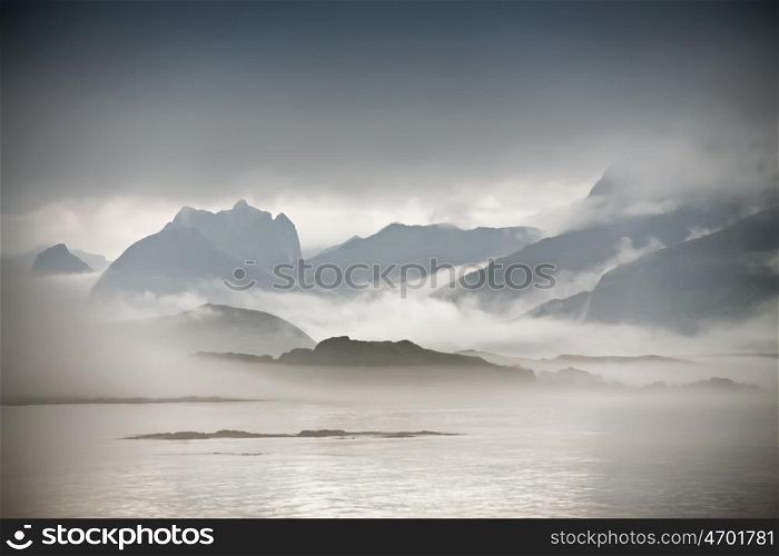 Coast of Norway sea in clouds of fog. Cloudy Nordic day on Lofoten islands