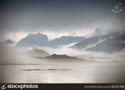 Coast of Norway sea in clouds of fog. Cloudy Nordic day on Lofoten islands