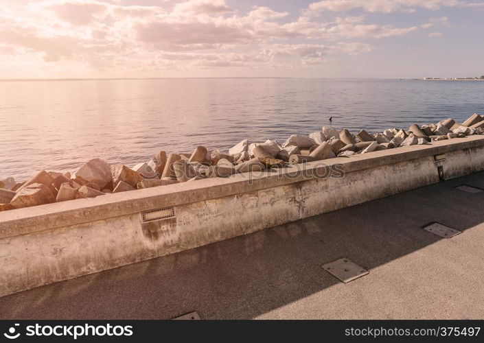 Coastline with concrete wave breaker in the shape of rocks