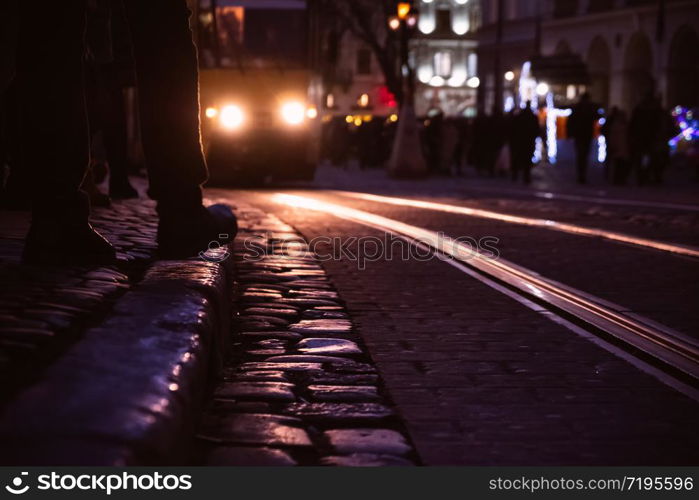 Cobble stones old european street with night city lights.