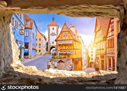 Cobbled street and architecture of historic town of Rothenburg ob der Tauber view through stone window, Romantic road of Bavaria region of Germany
