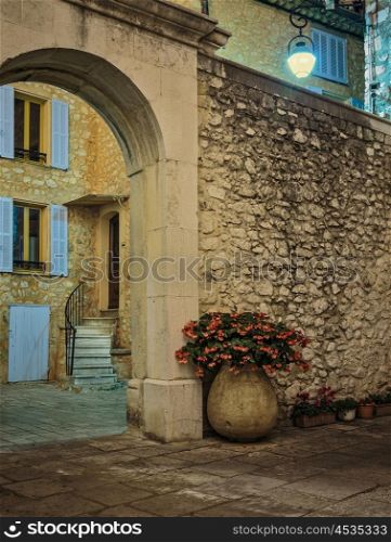 Cobbled street with flowers in the old village Tourrettes-sur-Loup at night, France.