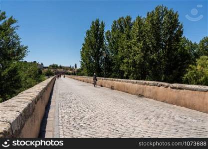 Cobbled surface of the old Roman Bridge leading away from the city of Salamanca in Spain. Old Roman bridge leading away from Salamanca in Spain