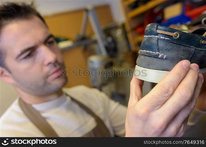 Cobbler holding a deck shoe