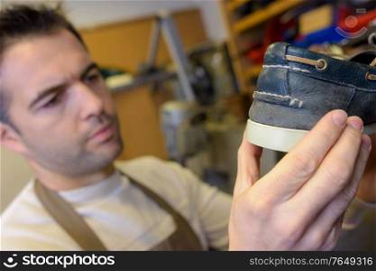 Cobbler holding a deck shoe