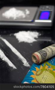cocaine drug powder over black abuse concept with digital scale over black