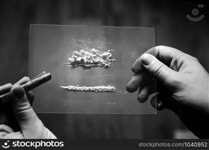 cocaine or speed in a line. addict with euro bill for snorting, drug abuse concept close-up crack, heroin black and white. cocaine or speed in a line. addict with euro bill for snorting, drug abuse concept close-up black and white