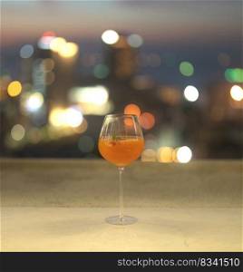 Cocktail beer alcohol drink glass on table in restaurant on balcony sky bar with urban city skyline background. Sweet fruit food in lifestyle concept at night.