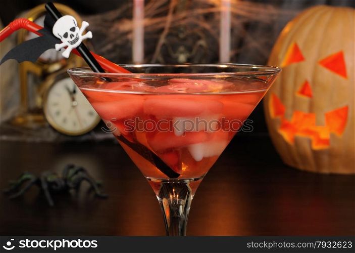 Cocktail glass filled with vampire teeth on the table for Halloween
