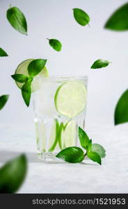 Cocktail Mojito or Lemonade with Lime, Mint and Ice on Light Background. Concept Fresh Summer Drinks.. Cocktail Mojito or Lemonade with Lime, Mint and Ice on Light Background. Concept Fresh Summer Drinks