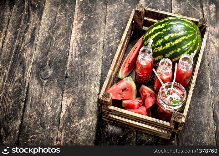 Cocktail of fresh watermelons in bottles. On a wooden background.. Cocktail of fresh watermelons in bottles.