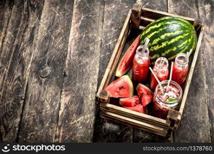 Cocktail of fresh watermelons in bottles. On a wooden background.. Cocktail of fresh watermelons in bottles.