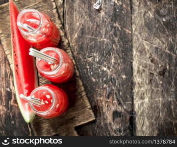 Cocktail of fresh watermelons in bottles. On a wooden background.. Cocktail of fresh watermelons in bottles.