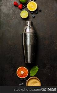 Cocktail shaker, tropical fruits and leaves on a dark background. Top view. Cocktail shaker, tropical fruits and leaves on a dark background