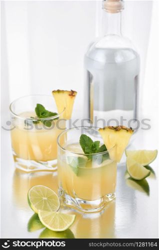 Cocktail silver tequila with pineapple juice, lime slice, cooled with ice and mint