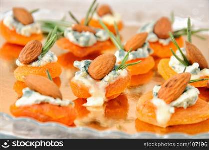 Cocktail snack from dried apricots with gorgonzola and almonds